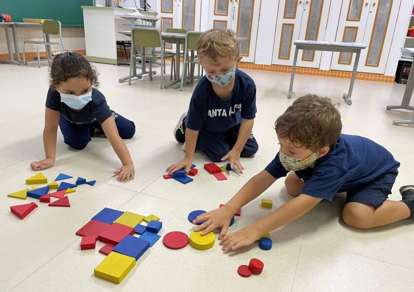 A foto mostra crianças da Educação Infantil  com pranchetas em pesquisa.